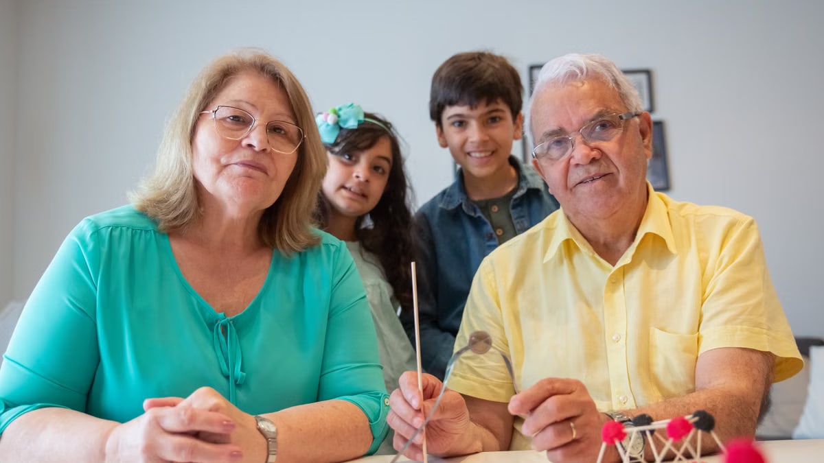 Grandparents engaging with grandchildren in an indoor activity, showcasing happy family bonding.